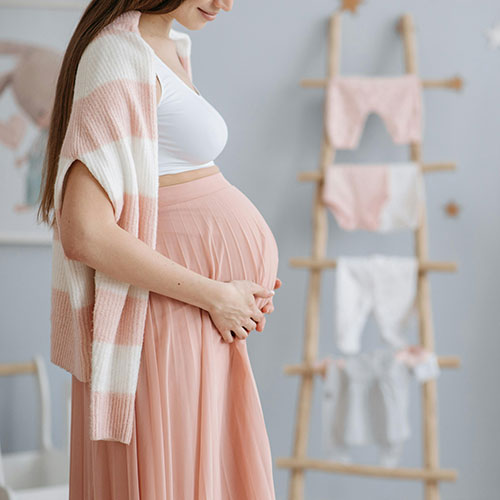 pregnant woman standing in the baby's room