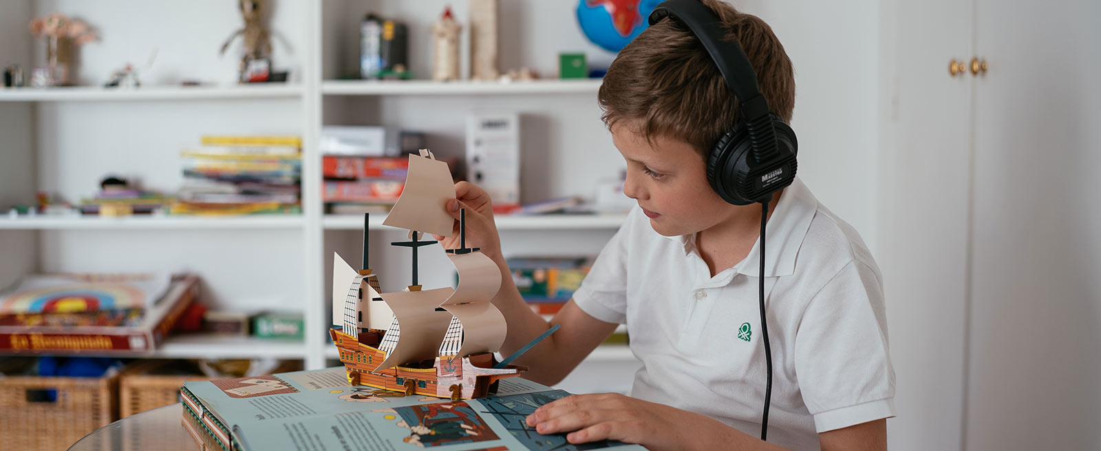 boy during listening therapy with Tomatis headphones playing with pop-up children's book
